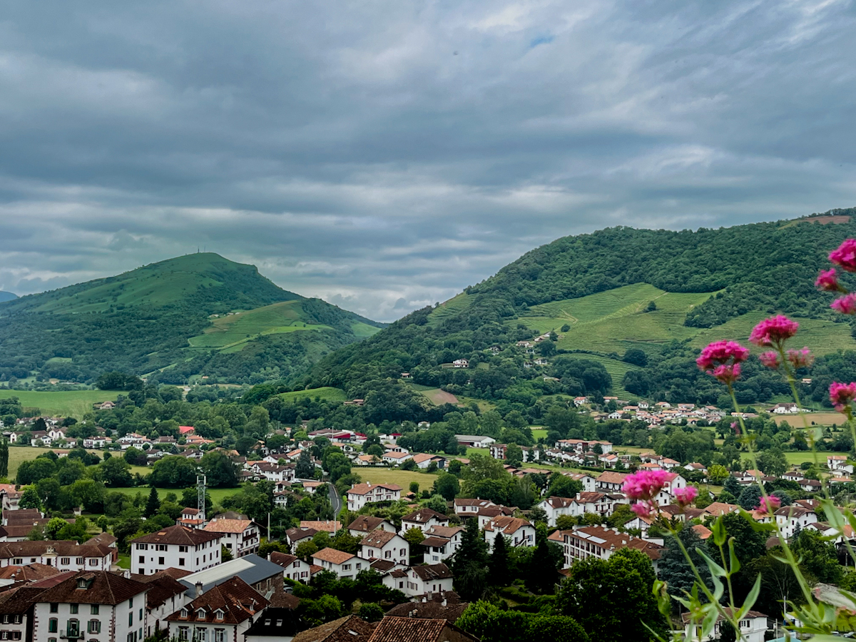 Saint-Jean-Pied-de-Port seen from above, red-roofed houses in a green valley beneath the Pyrenees