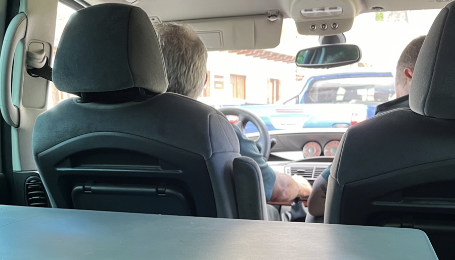 View from the back seat of a van, two Guardia Civil officers in the front seats, another patrol car visible ahead